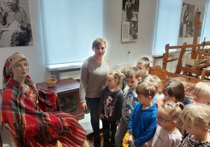 Przedszkolaki podziwiją strój galowy kobiety z ekspozycji w muzeum