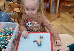 Dziewczynka układa mozaikę.