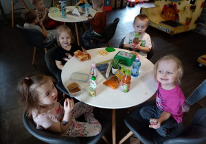 Dzieci przy stoliku spożywają przekąski