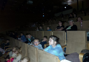 Dzieci z zaciekawieniem oglądają bajkę