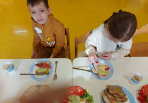 Dziewczynka i chłopiec przygotowują kanapki