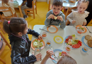 Dzieci jedzą przygotowane kanapki