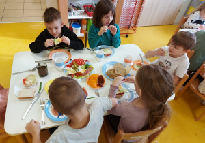 Dzieci jedzą przygotowane kanapki