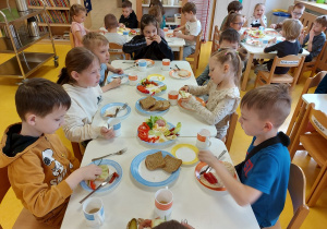 Dzieci ze smakiem zjadają kanapki