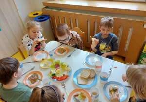 Dzieci ze smakiem zjadają kanapki