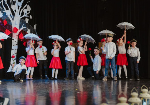 Zakończenie tańca zbiałymi parasolkami i czrwonymi różami - dzieci stoją w półkolu