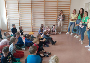 Dzieci słuchają listu, który wyjaśnia zasady zabawy
