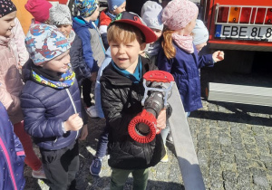Chłopiec trzyma wąż strażacki