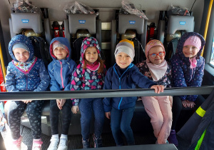 Dzieci siedzą w wozie strażackim