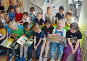 Przedszkolaki oglądają książki związane z ich zainteresowaniami