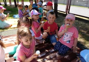 27 Dzieci jedzą lody na kocu