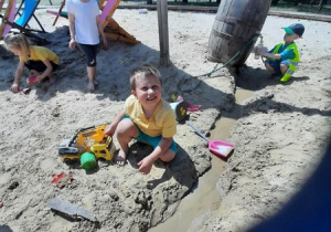 25. Chłopiec bawi się w piasku.