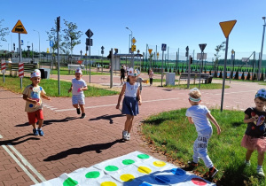 Dzieci biegają trzymając w rękach kolorowe kropeczki