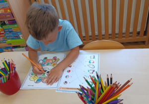 Chłopiec maluje kolorowankę