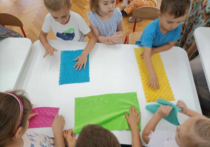 01 Dzieci dotykają kolorowych materiałów