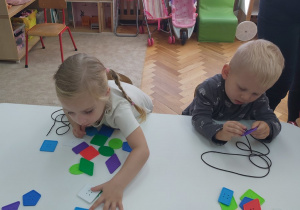 05 Dzieci nawlekają kolorowe ksztalły na sznurki