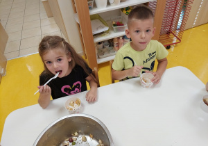 Chłopiec i dziewczynka próbują swojej sałatki.