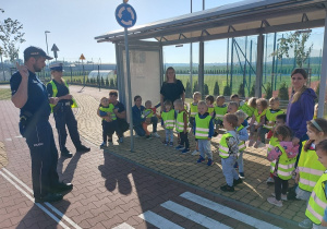 01 Dzieci na przystanku słuchają policjanta