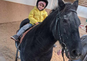 02. Uśmiechnięta dziewczynka jedzie na koniu