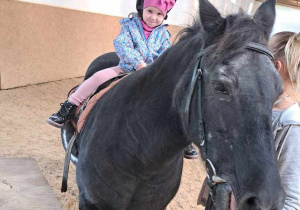 07. Zadowolona dziewczynka siedzi na koniu