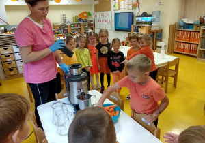 Dzieci robią sok z marchwi i jabłka.