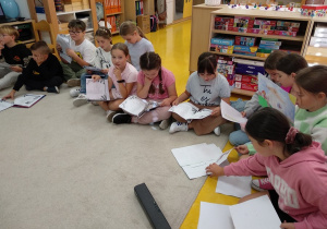 Uczniowie czytają przedszkolakom bajkę - Czerwonego Kapturka.