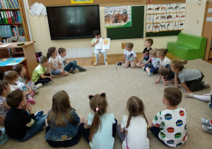 Dzieci słuchają opowieści swojego kolegi.
