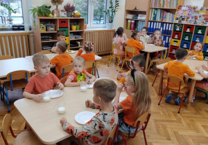 14 Dzieci jedzą ciasto dyniowe przy stolikach