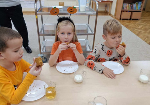 15 Dzieci jedzą ciasto dyniowe przy stoliku