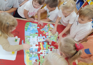 Dzieci układają puzzle z kolorowanki