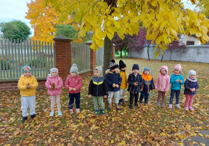 Grupowe zdjęcie przedszkolaków pod jesiennym drzewem