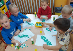 Dzieci wyklejają warzywa z kolorowego papieru