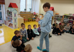 Chłopiec pokazuje dzieciom gekona.