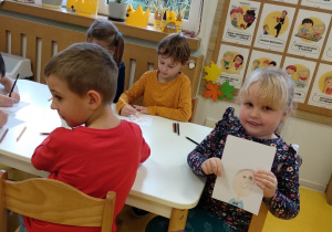 Dziewczynka prezentuje portret Olka.