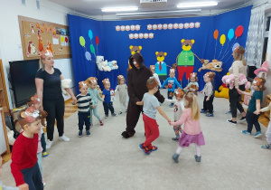 Dzieci tańczą w kole z misiami