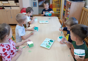 Dzieci malują zieloną farbą