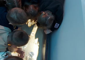 06. Dzieci szukają skamieniałości w piasku.
