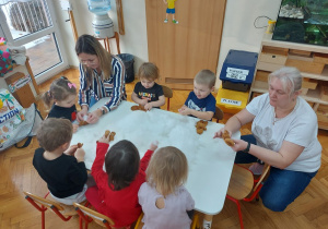 08 Dzieci z paniami przy stoliku wypełniają pluszowe ciasteczka