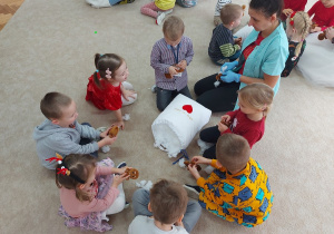 09 Dzieci z panią wypełniają pluszowe ciasteczka na dywanie