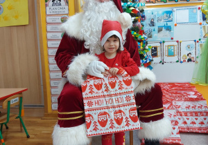Zdjęcie dziewczynki z Mikołajem przy choince