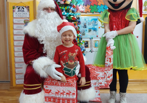 Zdjęcie chłopca z Mikołajem i Myszką MIki przy choince