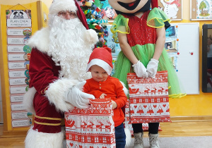 Zdjęcie chłopca z Mikołajem i Myszką MIki przy choince