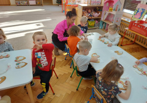 03 Dzieci przy stolikach dekorują z panią pierniki