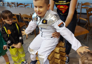 28. Chłopiec w stroju kosmonauty siada na wieży