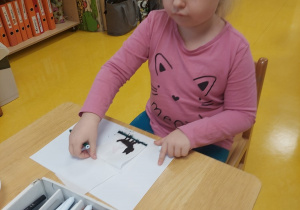 Dziewczynka rysuje mazakami.