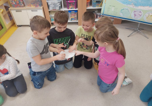 Przedszkolaki badają wielozmysłowo kostki lodu.