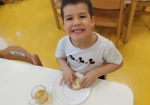 Chłopiec zajada się kanapką z jajkiem.