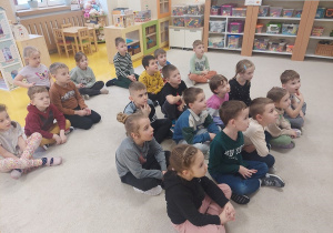 Przedszkolaki oglądają film o dinozaurach.