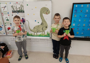 Chłopcy prezentują swoje dinozaury.