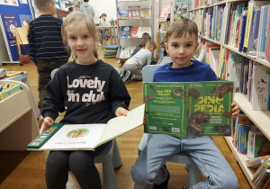 Chłopiec i dziewczynka przeglądają książki dla dzieci.